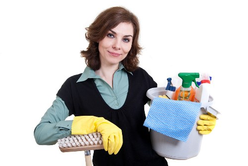 Cleaner wiping construction residue from a kitchen surface after renovation